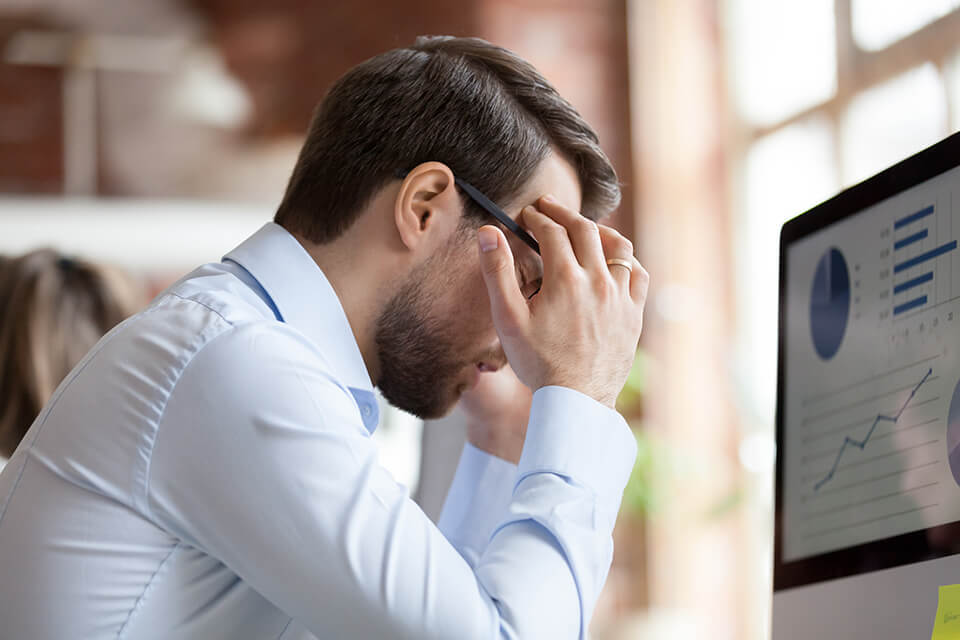 PCの前で悩んでる男性